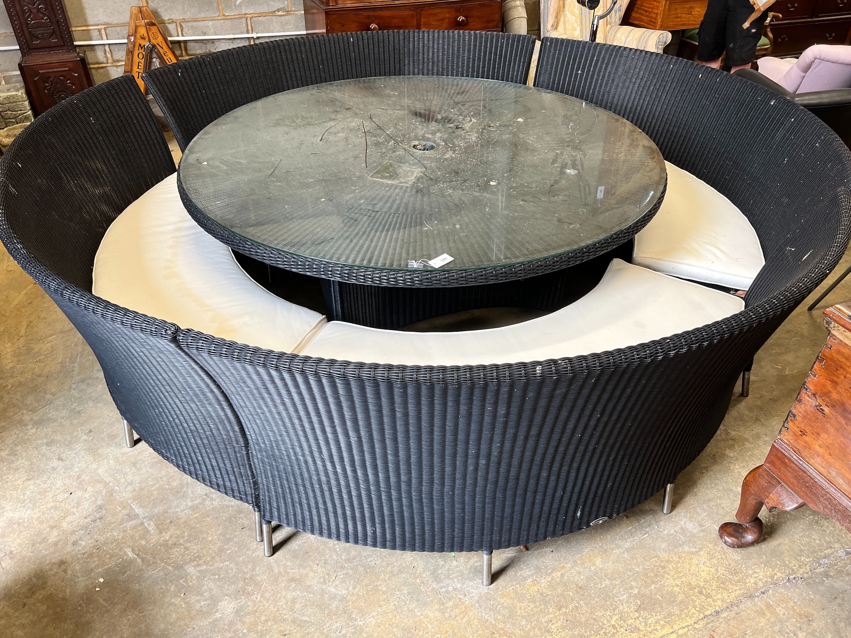 A large Westminster black all weather rattan circular topped garden table, diameter 180cm, height 74cm, together with four curved back seats and cushions